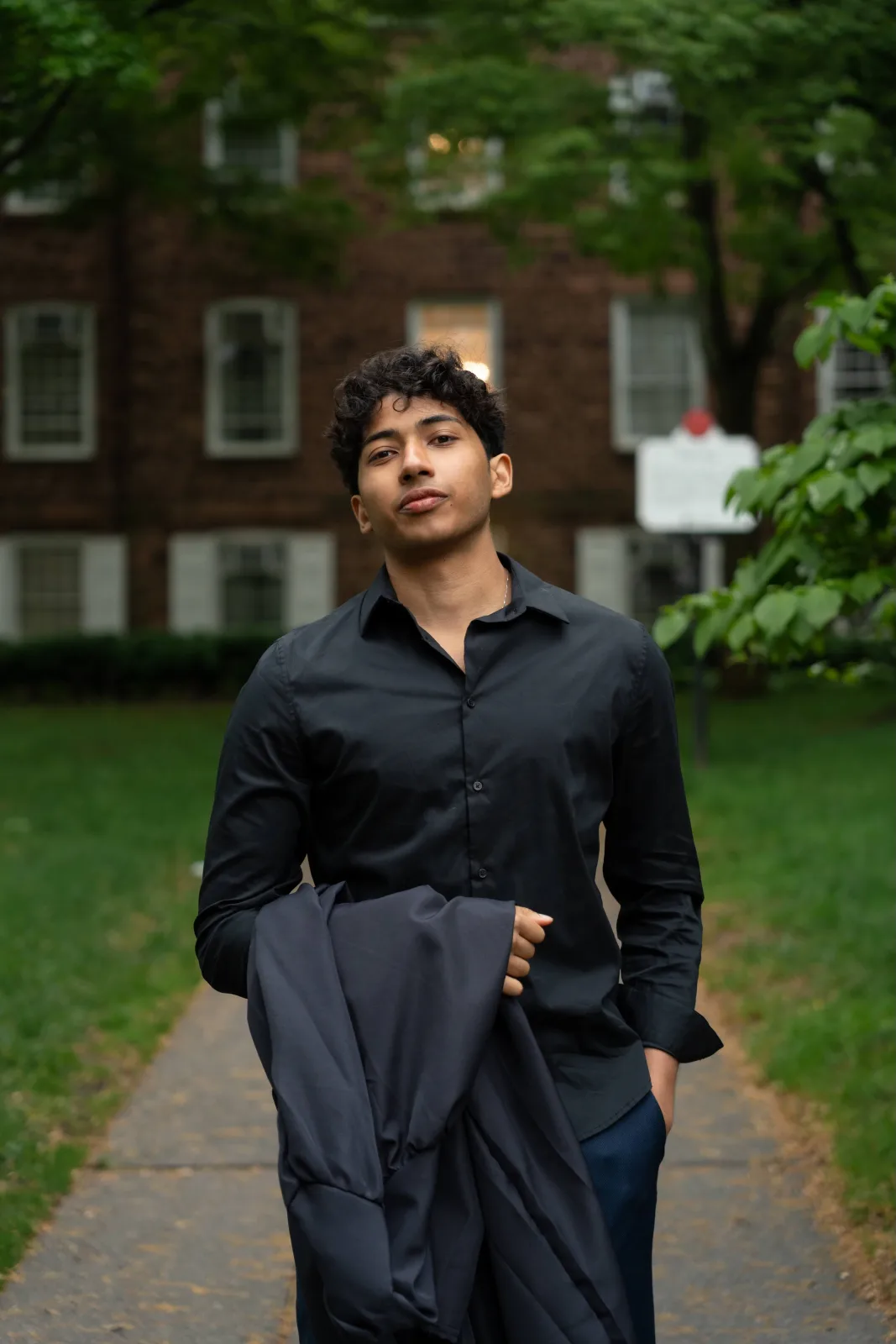 Ahaan Chaudhuri, standing on a campus path with a jacket over one arm